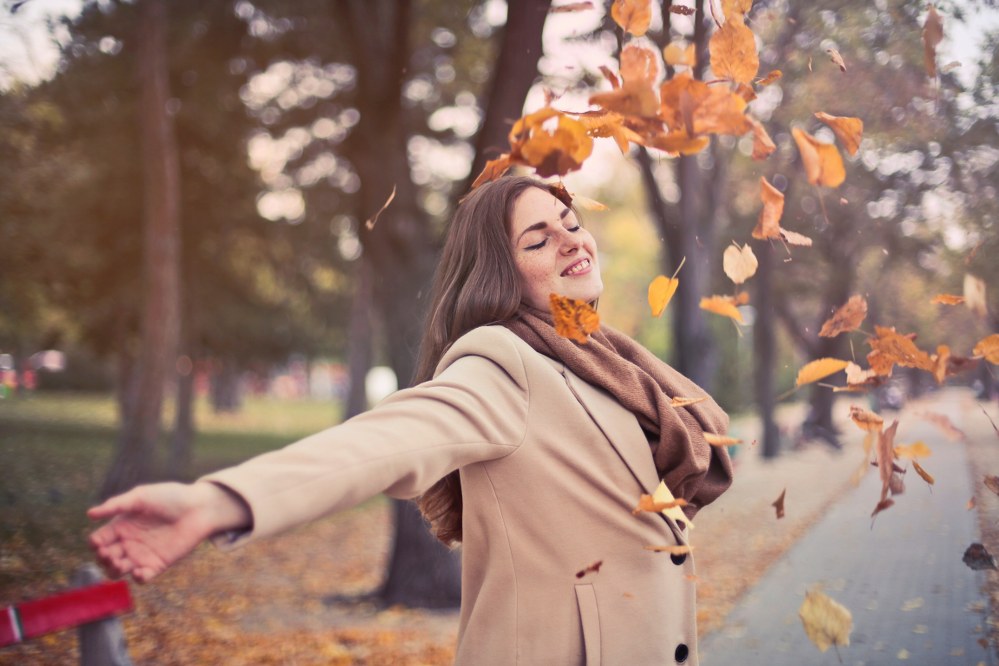 woman enjoying autumn leaves