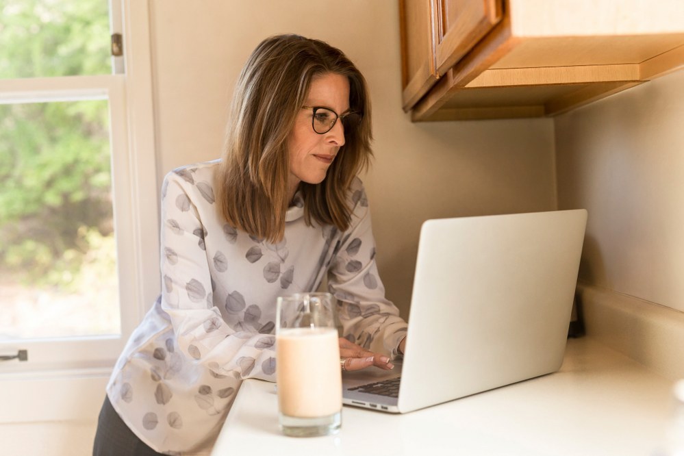 safe online dating for single parents - single mum on laptop in kitchen
