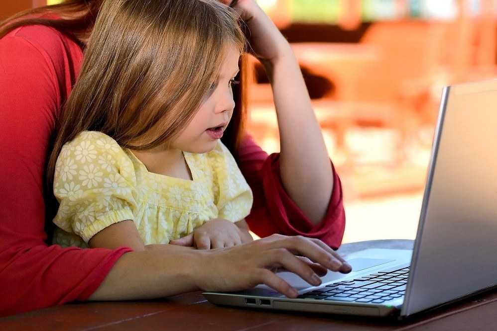 child on lap of mum in front of laptop