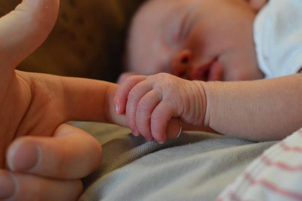 newborn holding parent's finger