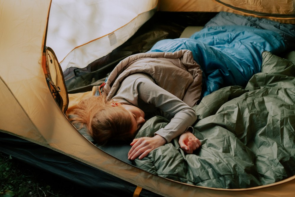 woman in sleeping bag in tent