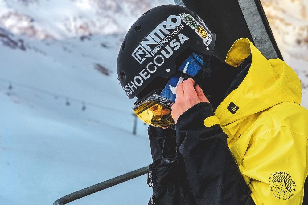 skier adjusting ski goggles in lift