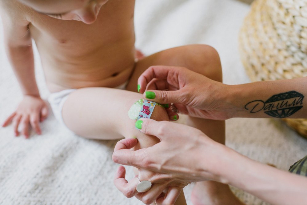 woman giving first aid to child