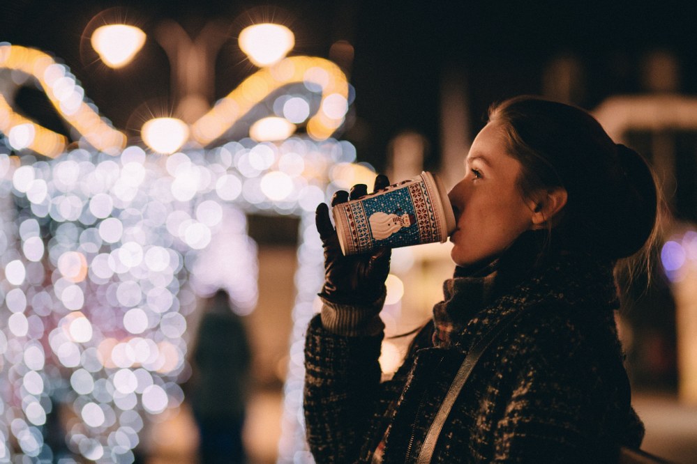 woman having hot drink at xmas market in UK