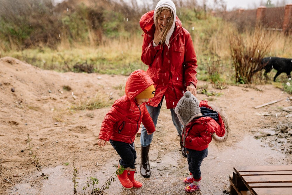 kids and mum jumping in muddy puddles