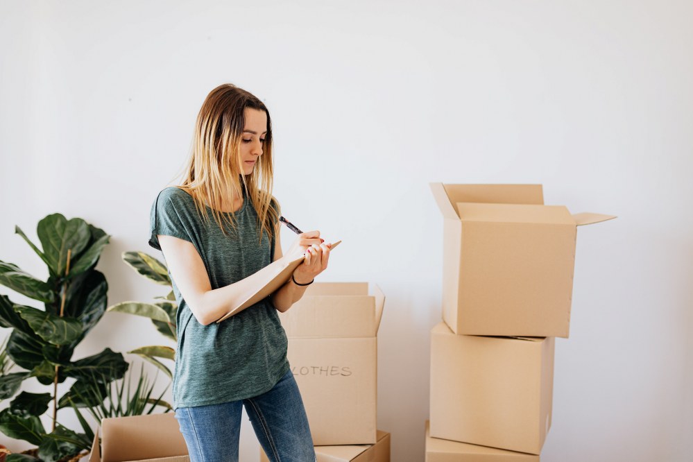 woman labelling boxes moving overseas