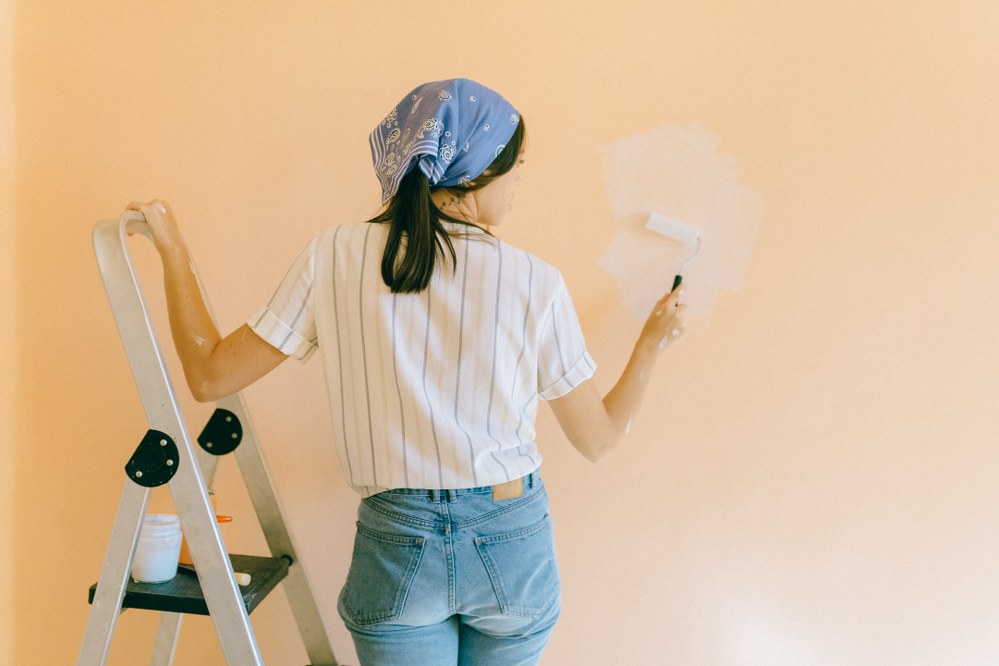 mum painting wall of kids bedroom