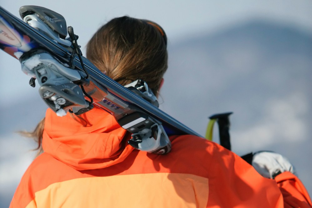 woman carrying skis