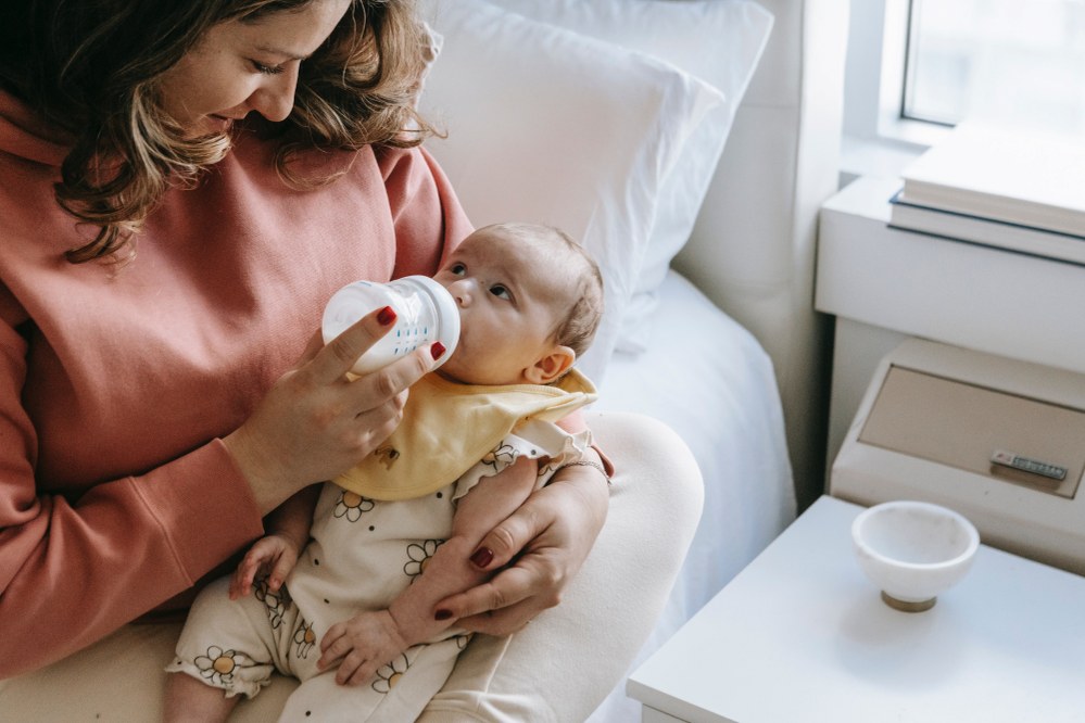 mum feeding baby bottle