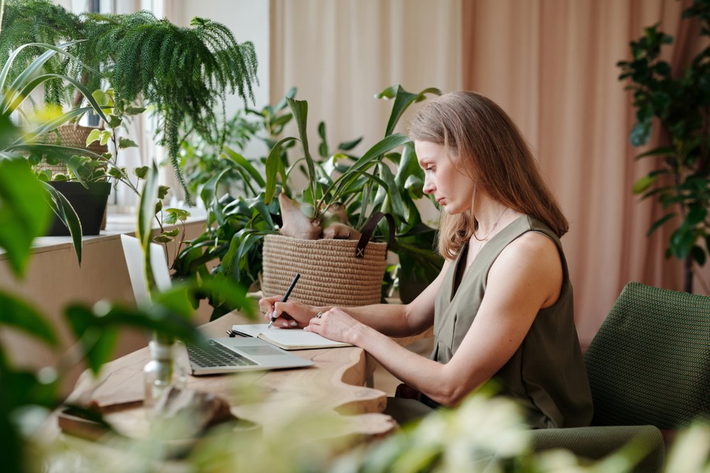 woman working at desk surrounded by plants