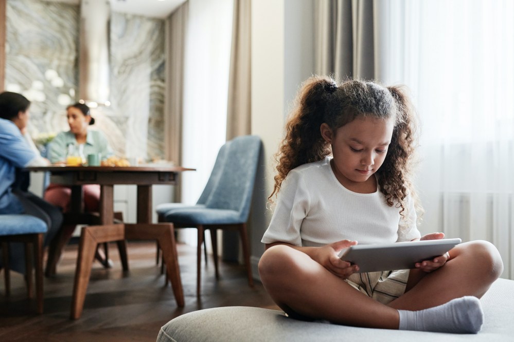 child using digital device in living room