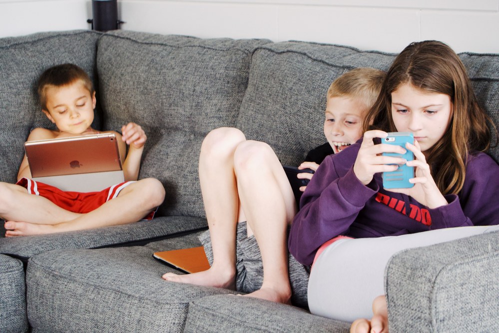 kids on sofa with tablets and phones - online safety for kids