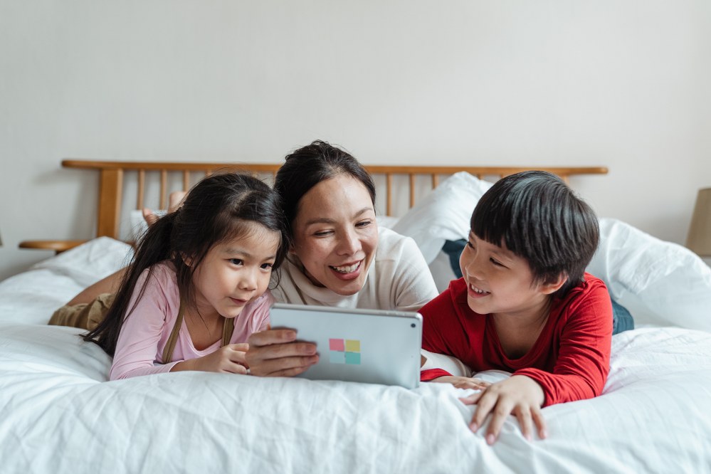 mum and kids in bed with laptop