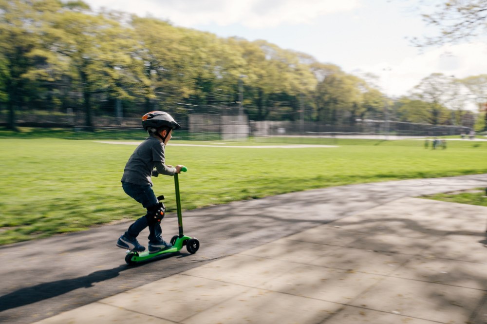 boy riding scooter in park